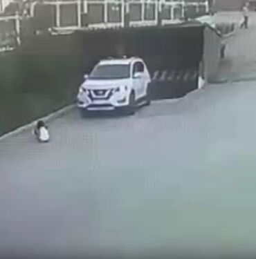 Garajdan çıkan araç yolda oturan çocuğu ezdi